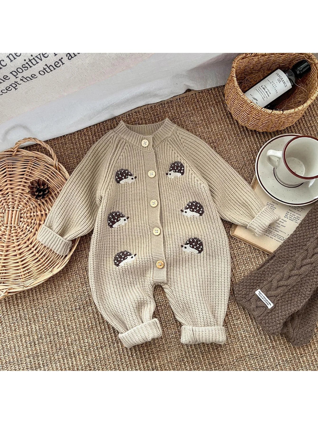 Beige knitted baby romper with hedgehog designs
