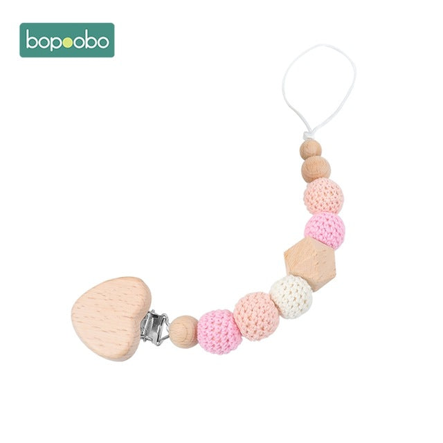 Soft peach and pink knitted balls on a dummy chain clip