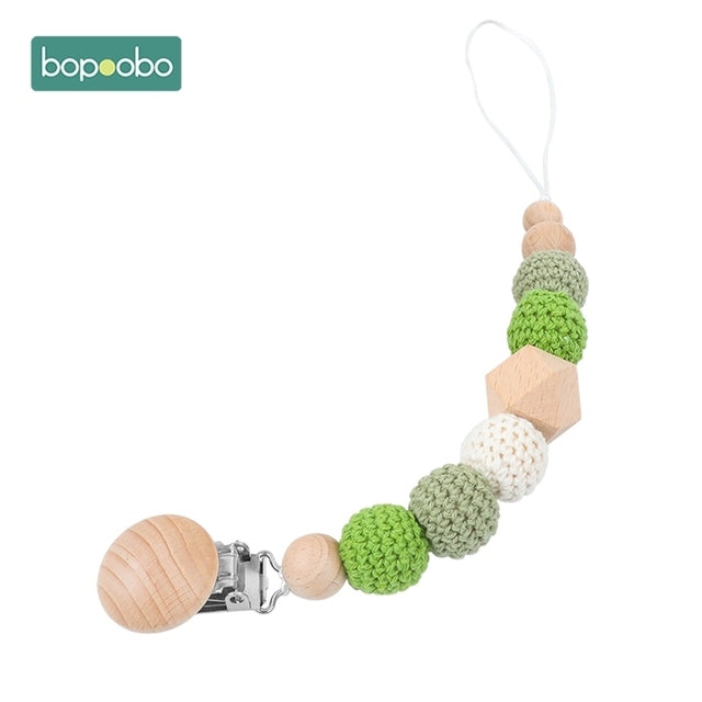 Green and white knitted balls on a dummy chain clip