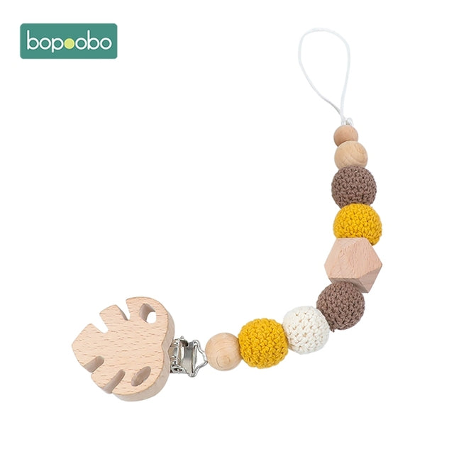 Wooden leaf with coloured knitted balls on a dummy chain clip
