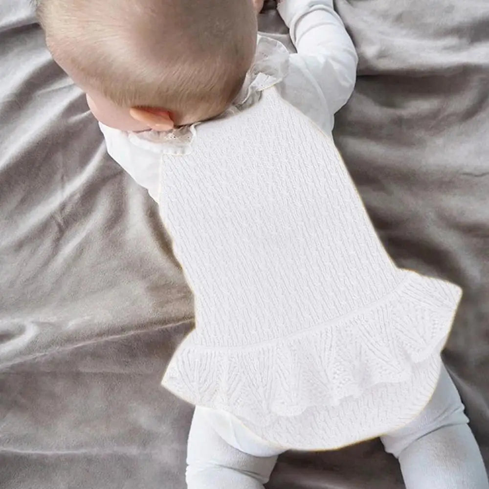 Baby wearing a white textured dress 