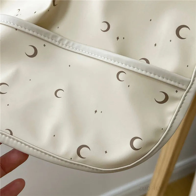 Beige bib with moon pattern