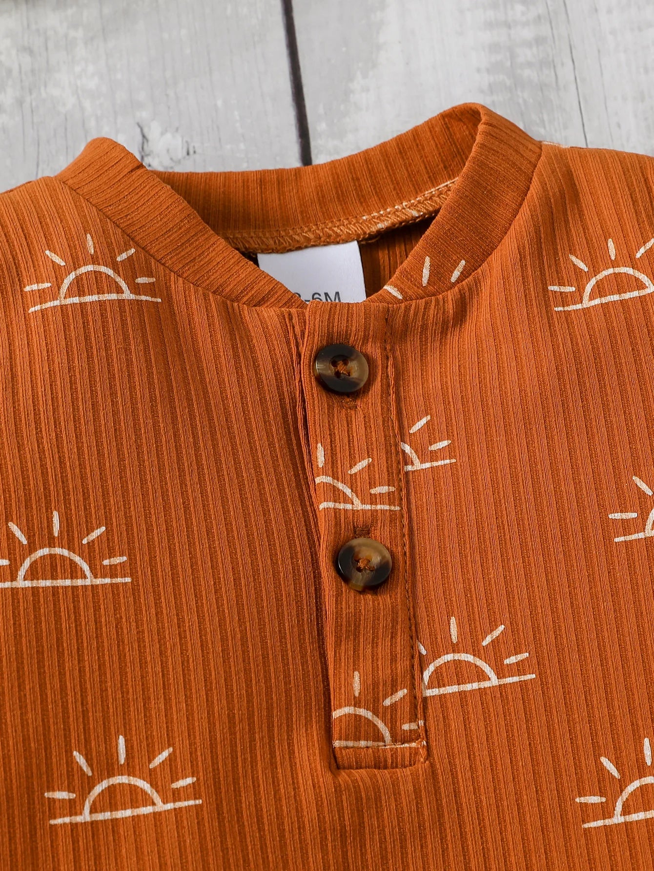 Orange children's shirt with sun patterns 