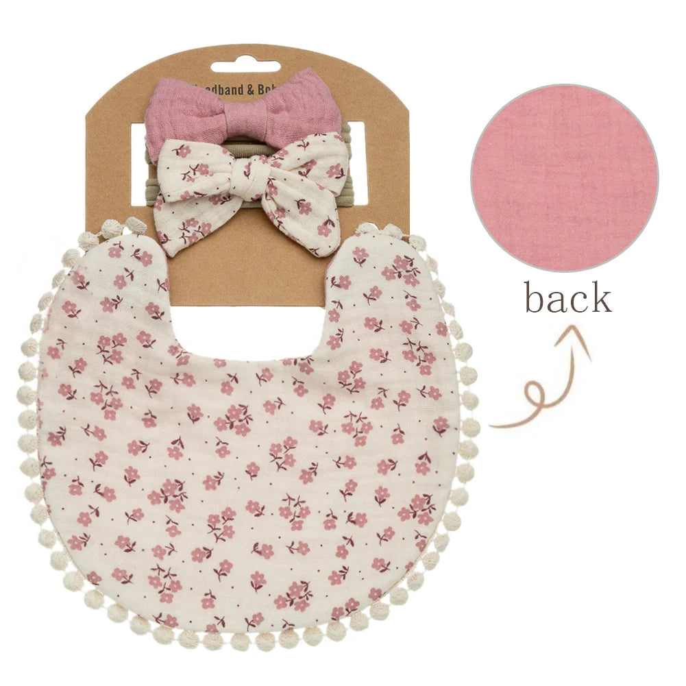 Soft pink colored flowers on a beige colored baby girls bib