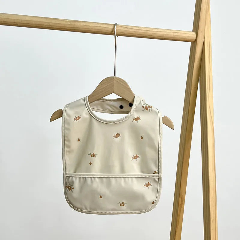 Beige baby bib with floral pattern 