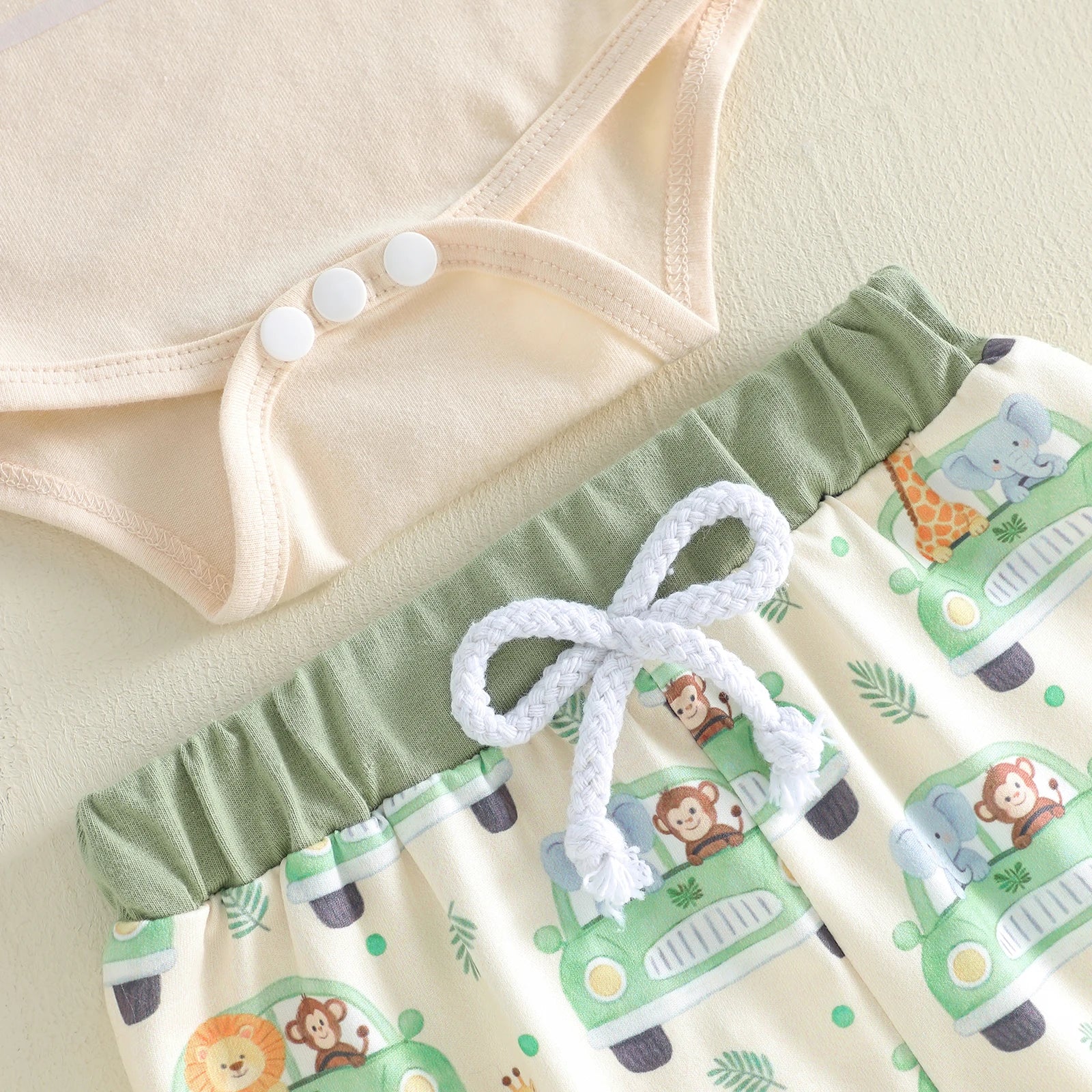 Baby outfit with green shorts featuring animal prints 