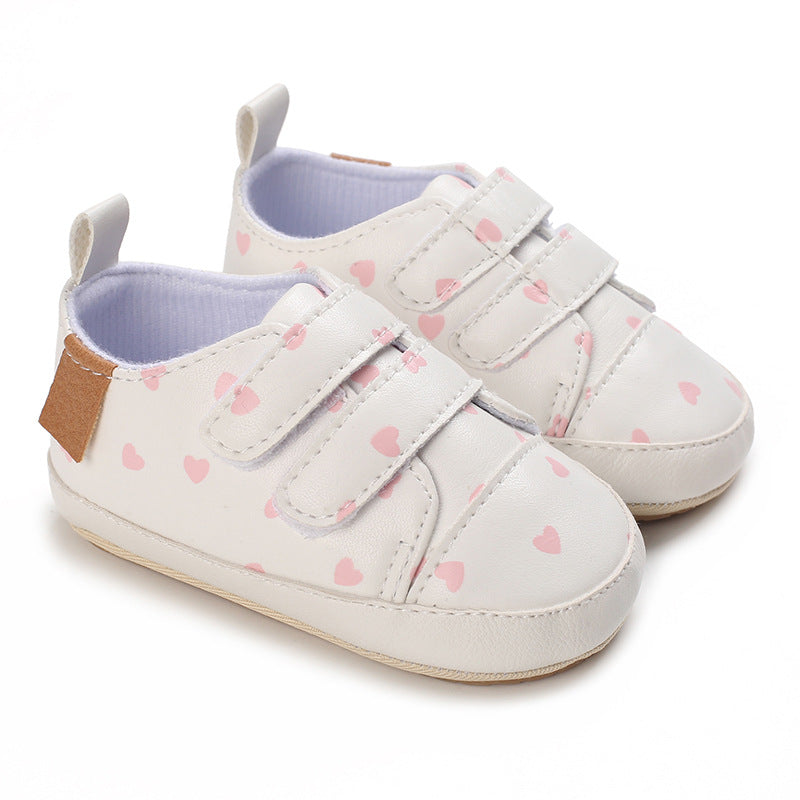 White baby shoes with pink heart pattern 