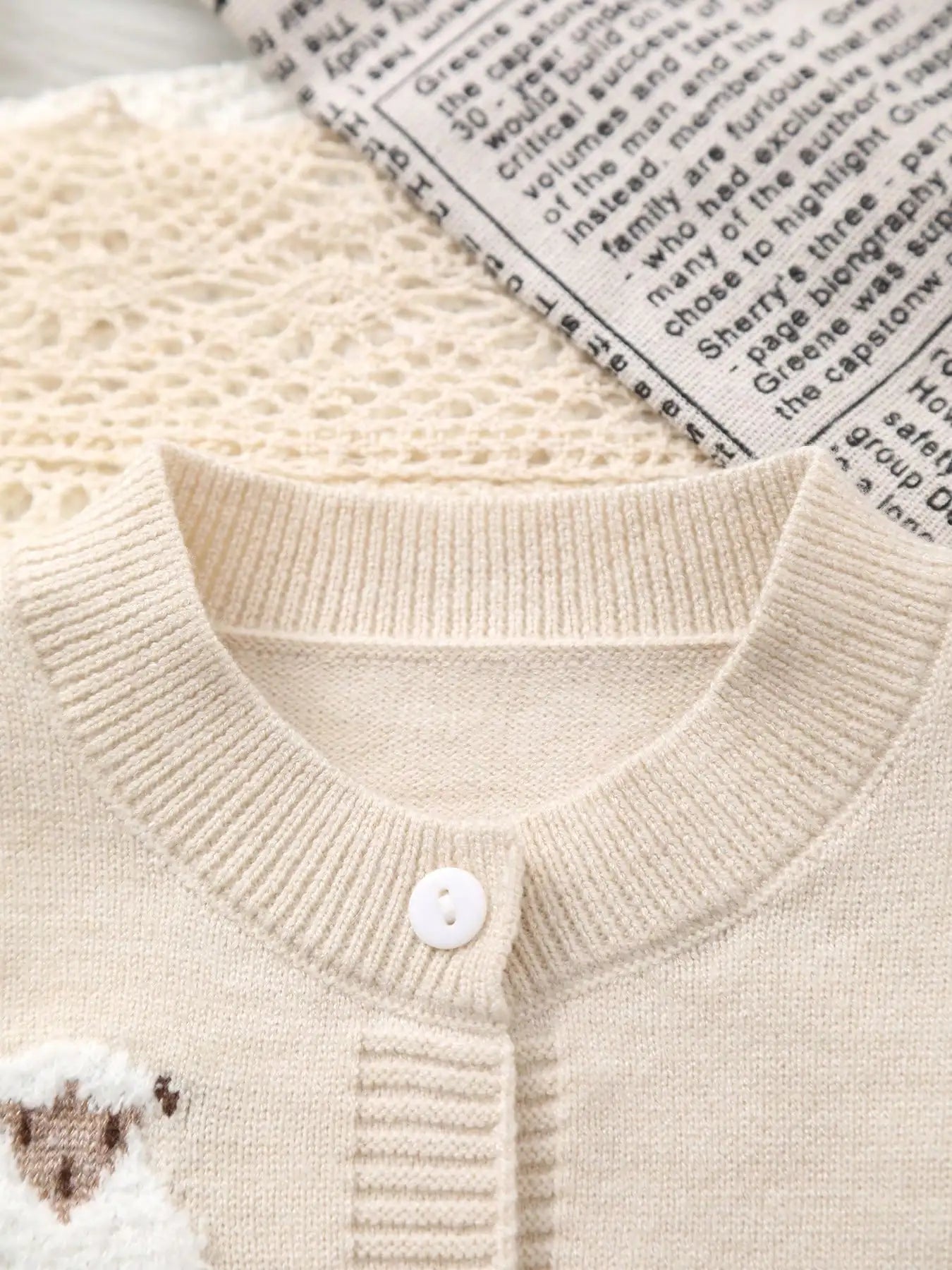 Close-up of a beige knitted cardigan with a button
