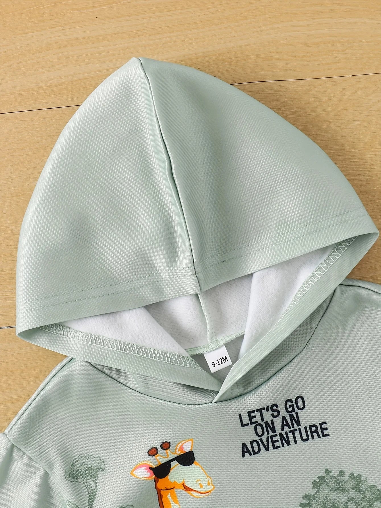 Light green hoodie with text and cartoon design