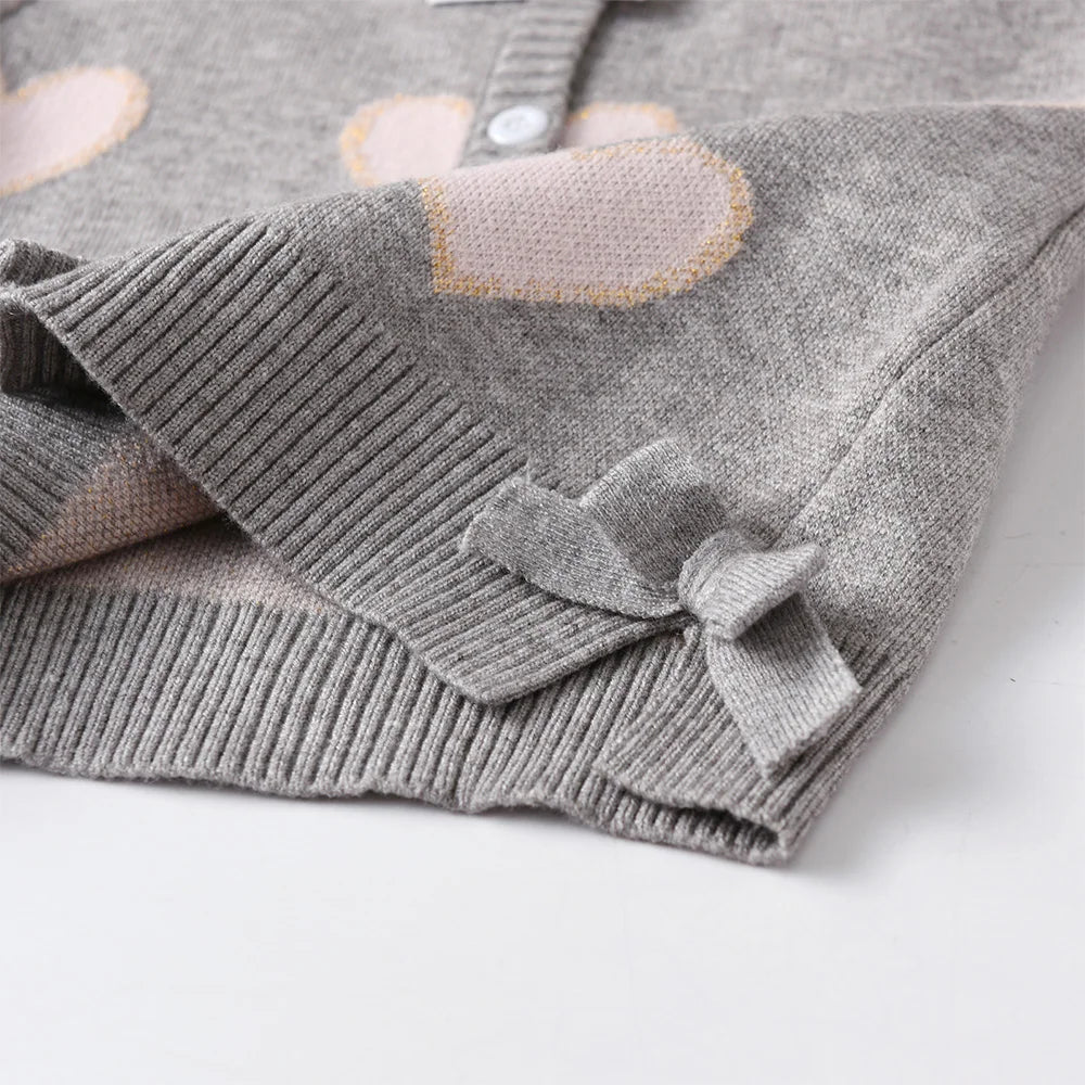 Folded gray baby blanket with pink heart designs 