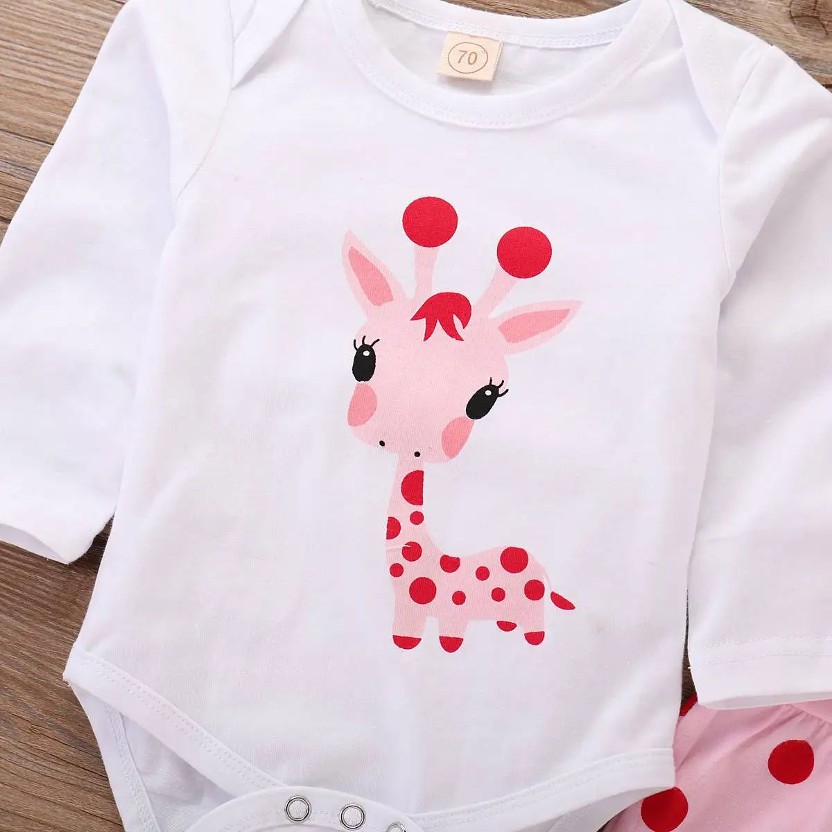 Very cute giraffe print on the front of a baby girl romper suit