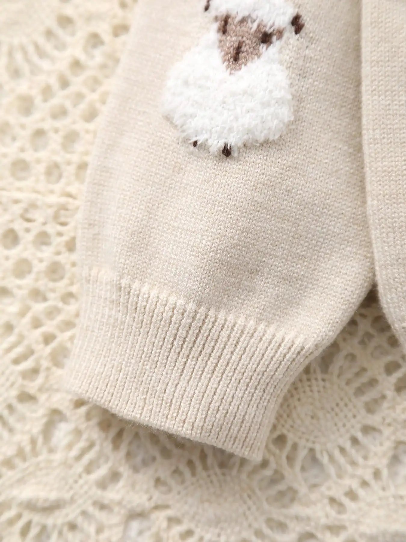 Beige baby bootie with a soft sheep design