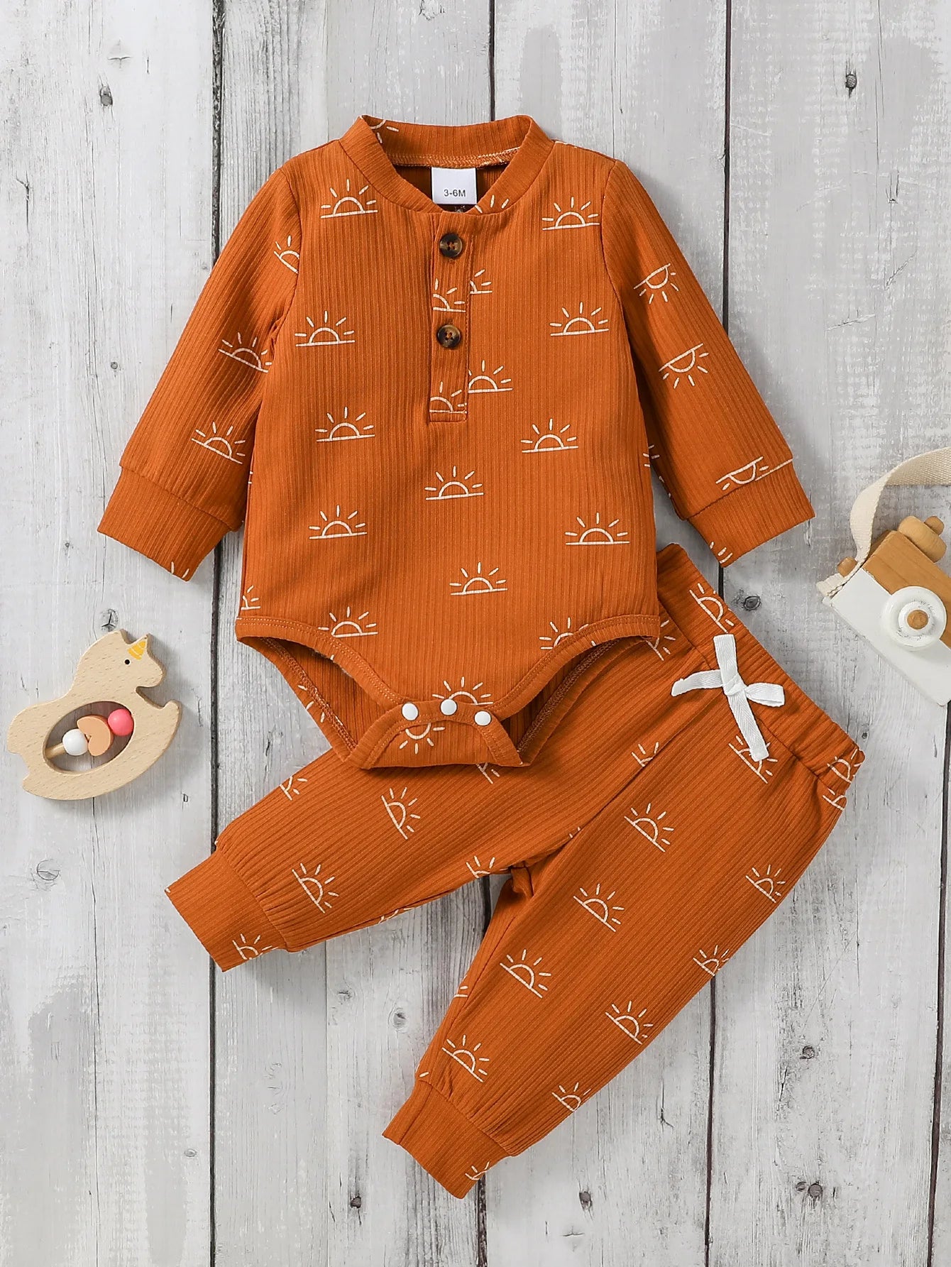 Orange baby outfit with sun patterns 